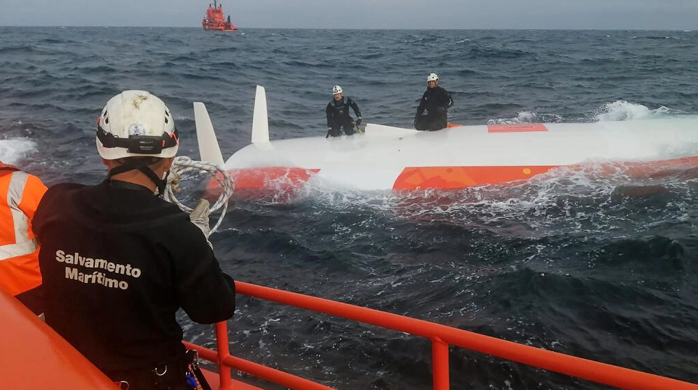 Rescatistas de pie sobre el casco del velero Jeanne Solo Sailor volcado, a 22 kilómetros de las costas de las islas Sisargas, en la región de Galicia, España. Foto: AFP.