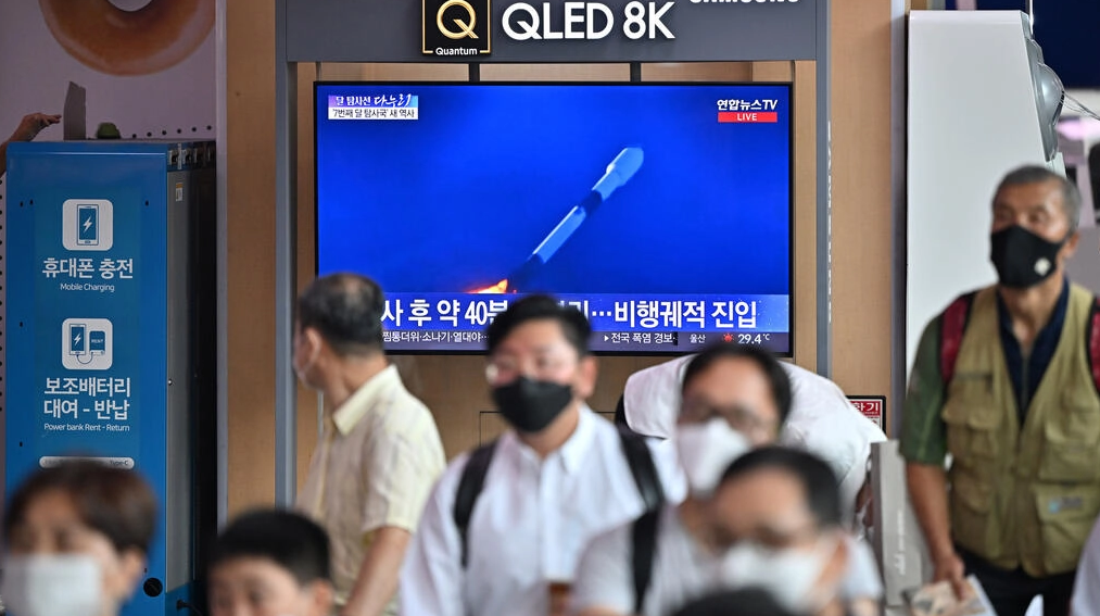 Una pantalla de televisión de una estación de tren de Seúl muestra el lanzamiento de un cohete SpaceX Falcon 9 con la primeras sonda lunar espacial de Corea del Sur a bordo. Foto: AFP.