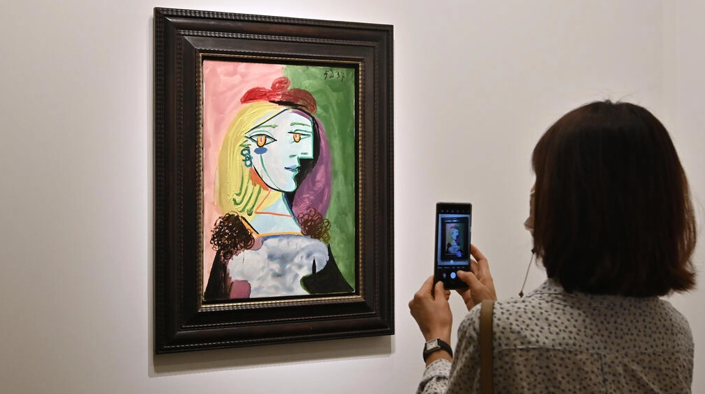 Una mujer toma una foto de una pintura de Pablo Picasso en la feria de arte Frieze Seúl. Foto: AFP.