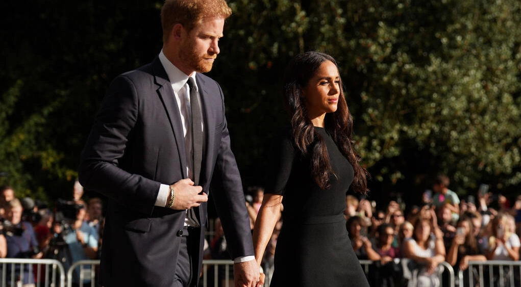 El príncipe Enrique y su esposa Meghan, llegan junto a los tributos florales en el camino al castillo de Windsor, el 10 de septiembre de 2022. Foto: AFP.