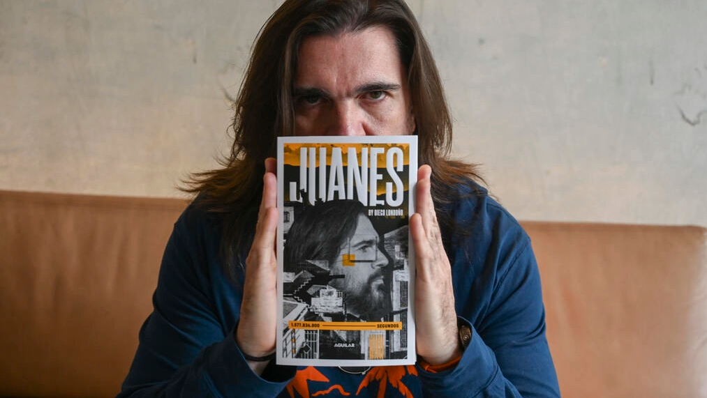 El músico colombiano Juanes posa con su libro biográfico del escritor Diego Londoño, en Bogotá, el 14 de septiembre de 2022. Foto: AFP.