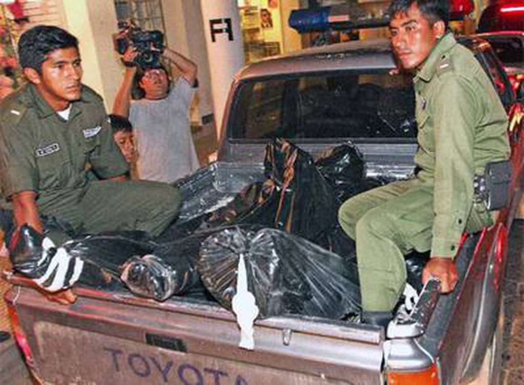 Policías retiran los cuerpos de los acribillados en el hotel Las Américas. Foto: AFP
