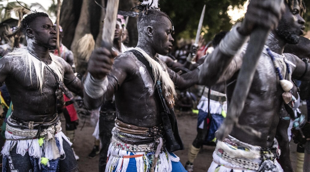 Jóvenes con ropa tradicional cantan y bailan en un antiguo rito que marca el fin de un proceso anual de iniciación para jóvenes en Kabrousse, Senegal. Foto: AFP.
