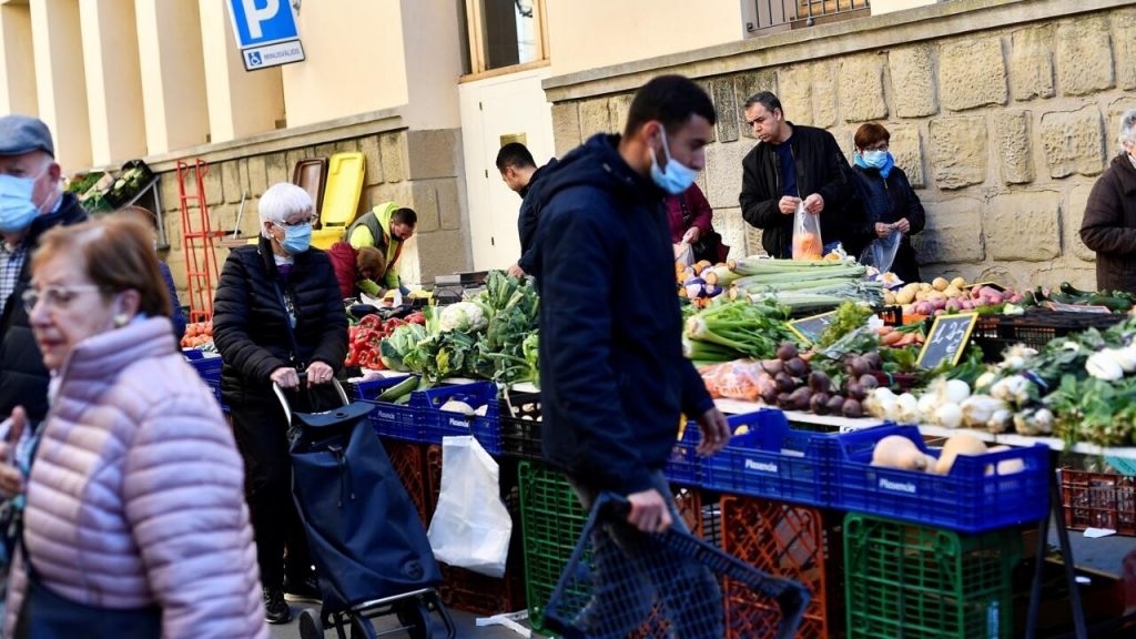 Varias personas compran en un mercado callejero del pueblo catalán de Guissona, cerca de Lérida, en un ejemplo del alza de costos de alimentos en España. Foto: AFP.