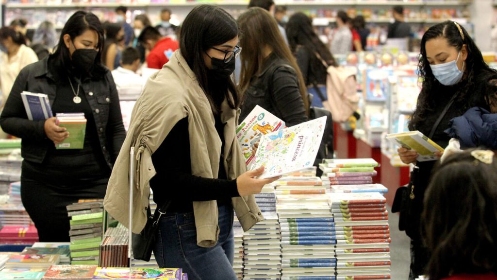 Personas ojean libros durante el tercer día de la Feria Internacional del Libro de Guadalajara, en Guadalajara, México, el 29 de noviembre de 2021. Foto: AFP.