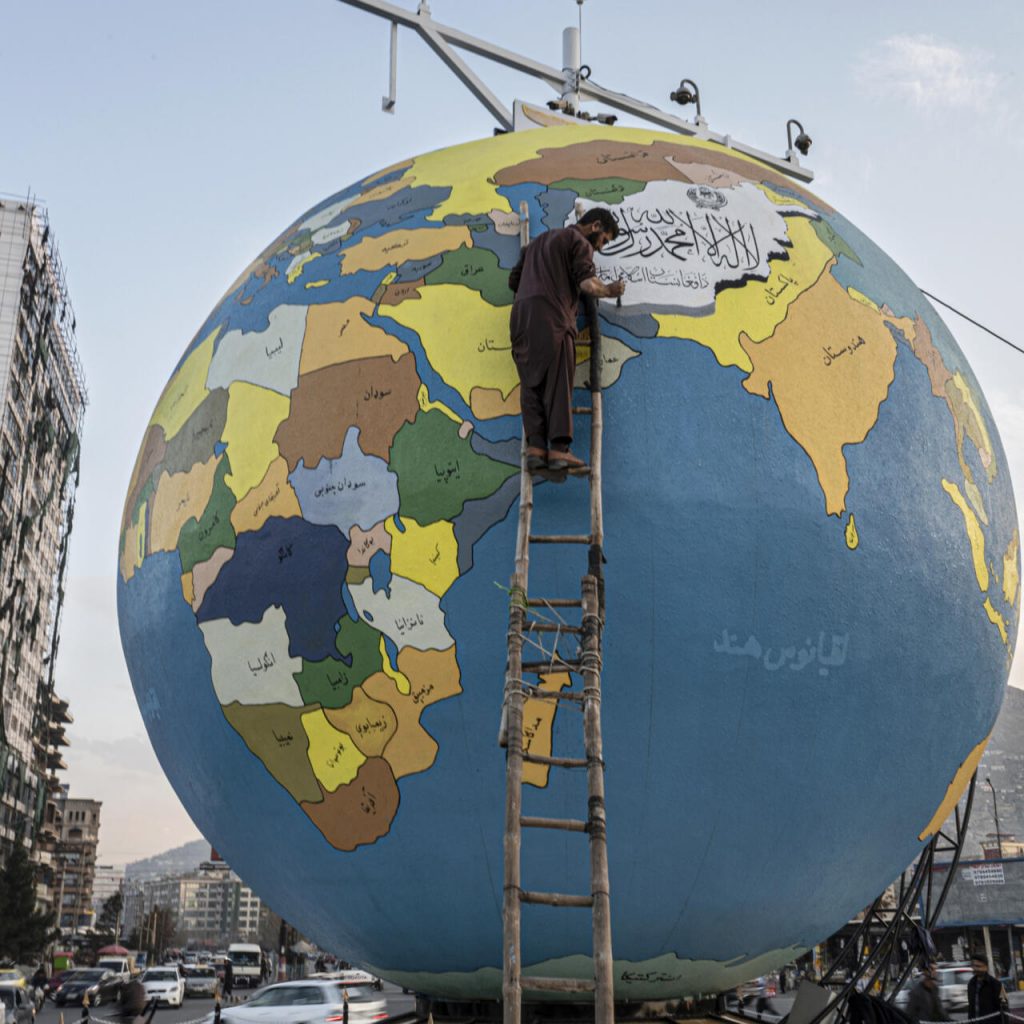 Foto tomada el 6 de diciembre de 2022 en la que un pintor da el toque final a un globo terrestre gigante instalado por el municipio en la plaza Dahan e Bash, en Kabul. Foto: AFP.