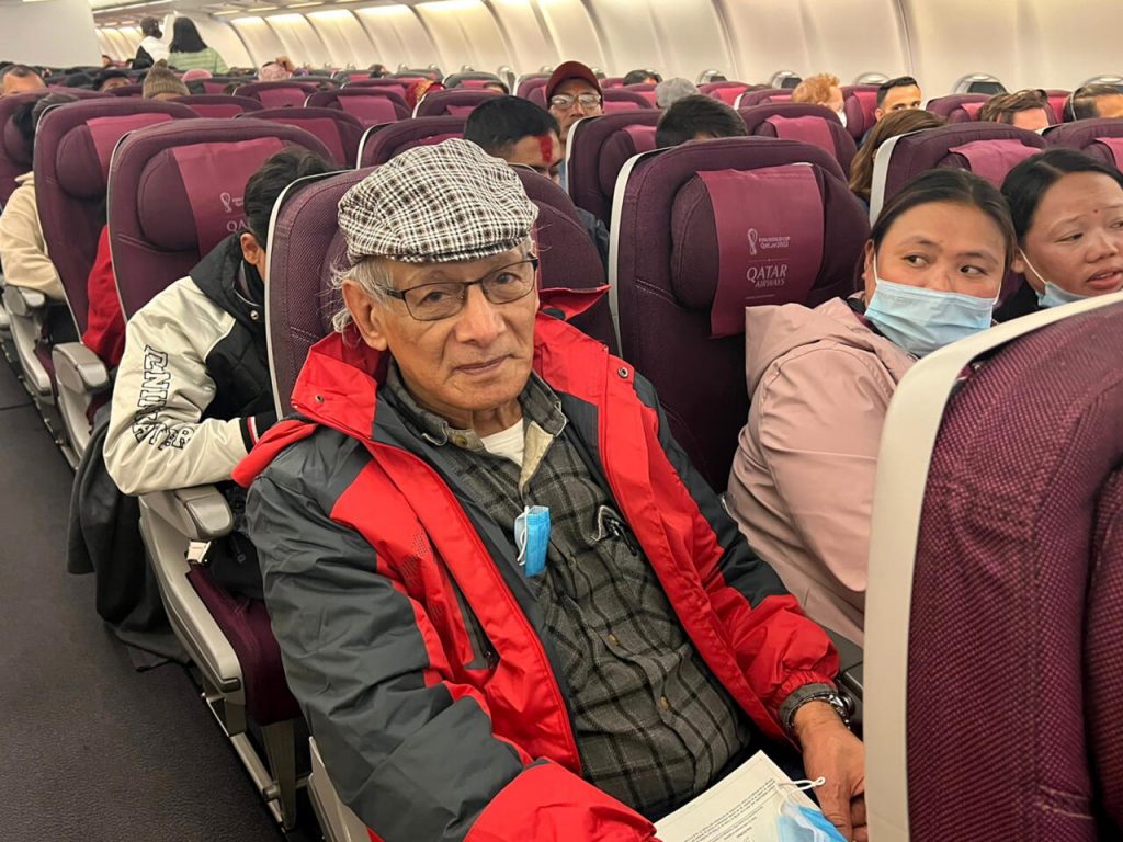 El asesino en serie francés Charles Sobhraj, en su asiento del avión con destino Francia, el 23 de diciembre de 2022 en Katmandú. Foto: AFP.