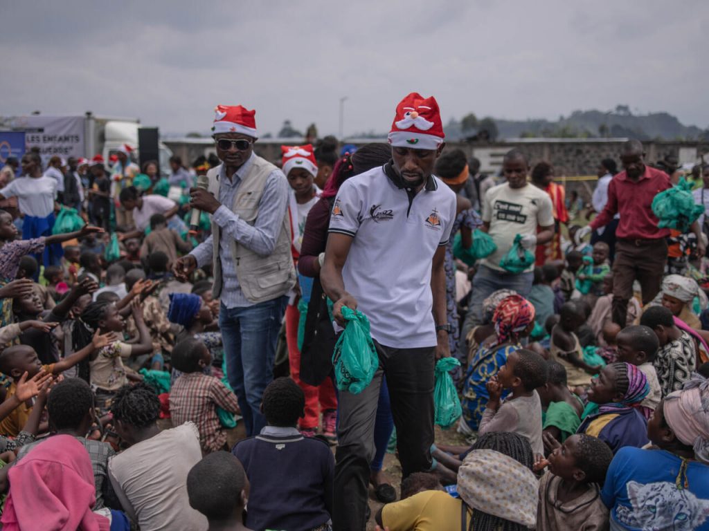 Miembros de la organización Un Jour Nouveau reparten regalos entre niños desplazados al norte de Goma, RD Congo, el 24 de diciembre de 2022. Foto: AFP.