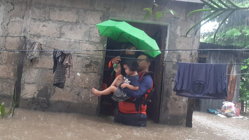 Un rescatista ayuda a evacuar a una niña en la ciudad filipina de Ozamiz, el 25 de diciembre de 2022. Foto: AFP.