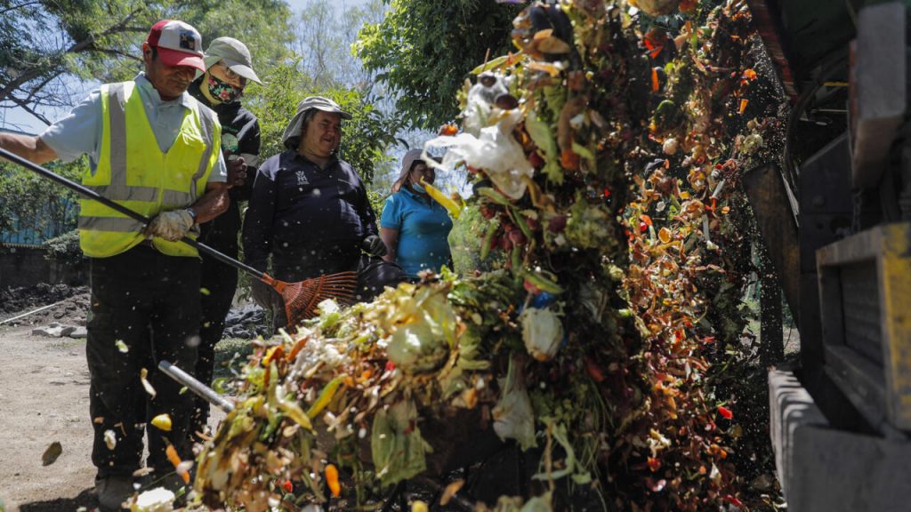 Funcionarios municipales de recogen desechos orgánicos en el barrio La Pintana de Santiago de Chile. Foto: AFP.