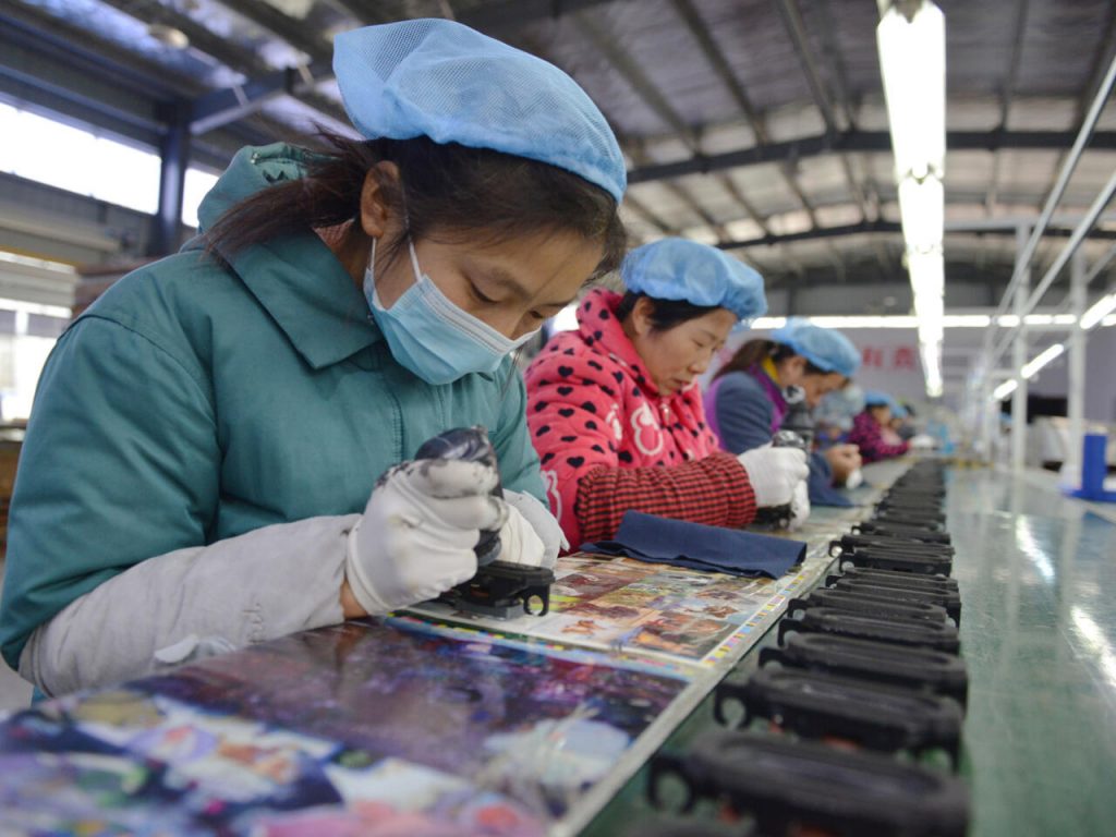 Mujeres trabajan en la línea de ensamblaje de una fábrica de parlantes en la ciudad de Fuyang, este de China, el 30 de noviembre de 2022. Foto: AFP.