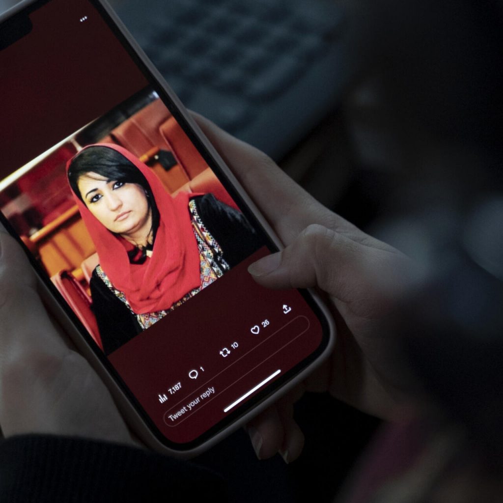 Una mujer afgana ve en su teléfono móvil una imagen de la asesinada Mursal Nabizada el 15 enero de 2023 en Kabul. Foto: AFP.