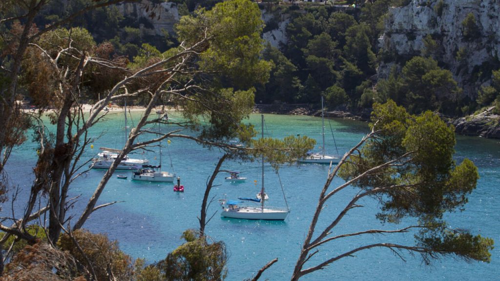 Varias embarcaciones permanecen fondeadas en las aguas azules y turquesas de Cala Galdana, en Ferreries, el 22 de junio de 2017 en la isla española de Menorca, en el archipiélago mediterráneo de las Baleares. Foto: AFP.