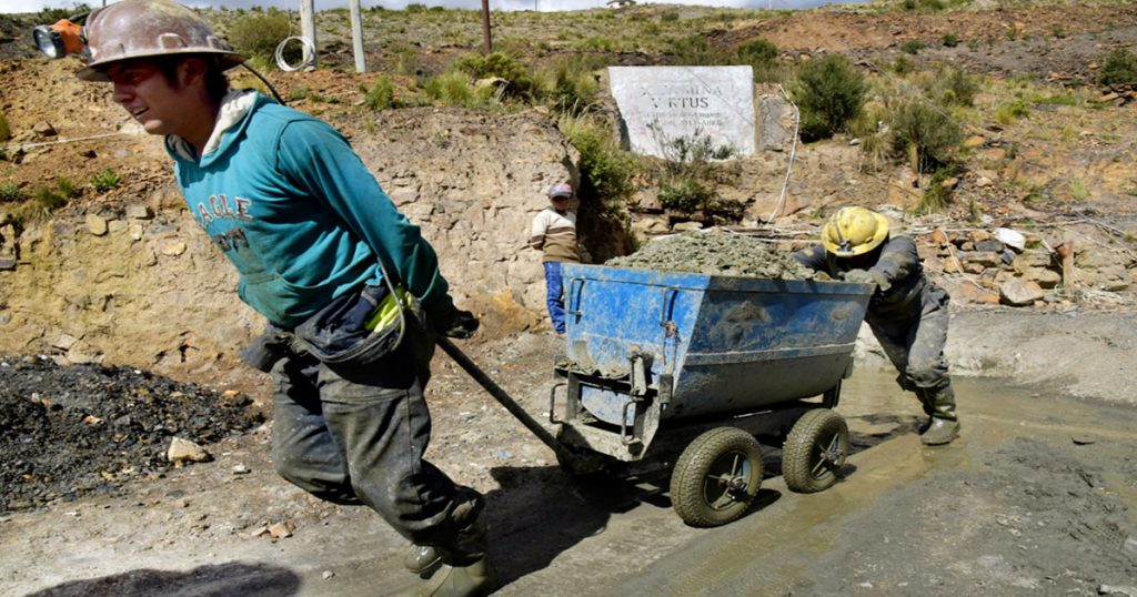 Trabajadores mineros extraen el mineral del socavón.