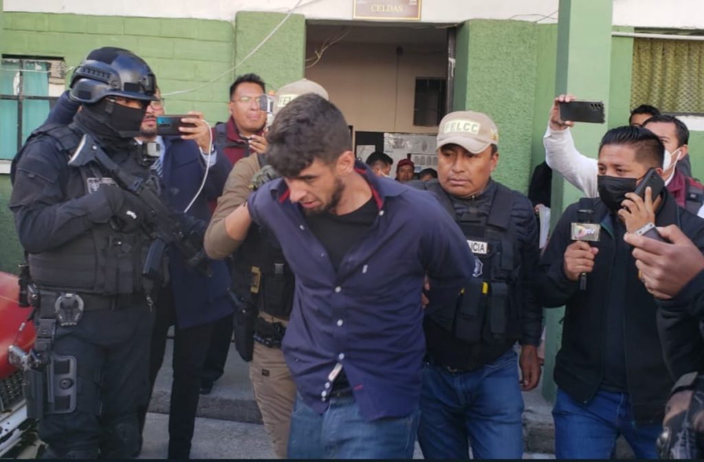 El reo recapturado es llevado bajo fuerte resguardo policial. Foto: Roberto Guzmán.