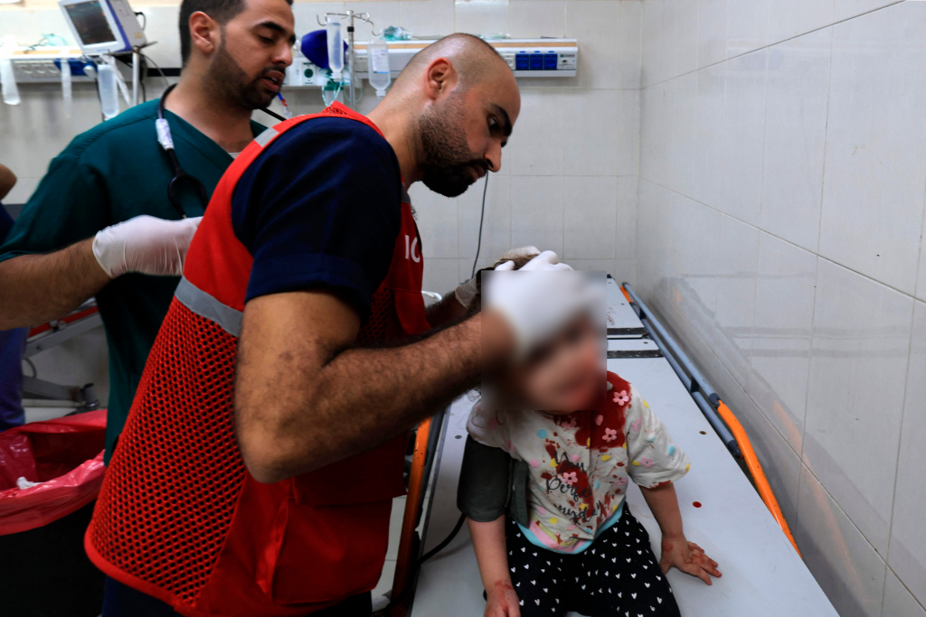 Mahmud al Astal atendiendo una niña en el hospital de Gaza. (Foto AFP)