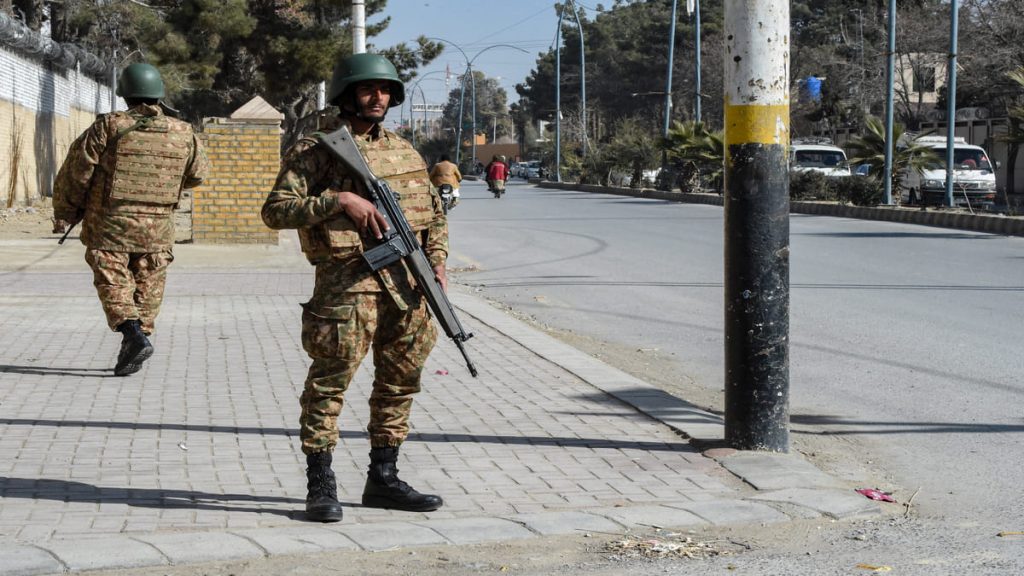 Personal del ejército paquistaní hace guardia a lo largo de una carretera en Quetta el 7 de febrero de 2024, un día antes de las elecciones nacionales de Pakistán.