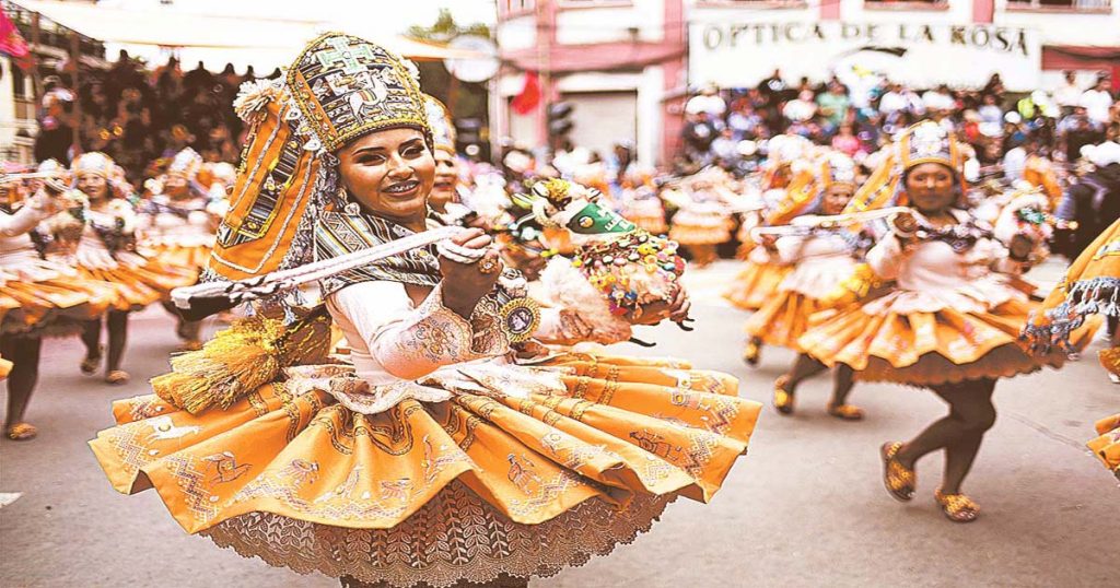 Al son de la música, mujeres realizan la danza de la llamerada con sus coloridos trajes.