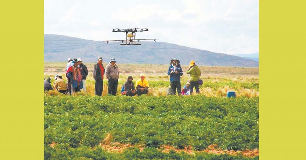 Comunarios utilizando un dron especializado para mejorar los resultados de sus cultivos.